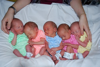 Baudinet quintuplets cradled by mom's hands