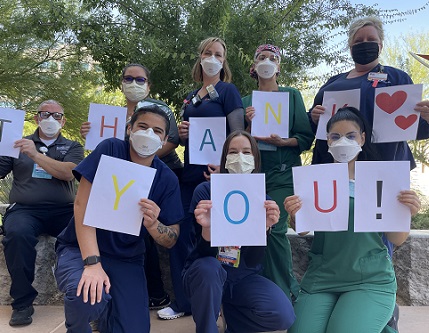 employees holding thank you signs