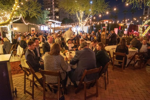 Tables of people talking at evening fundraising event