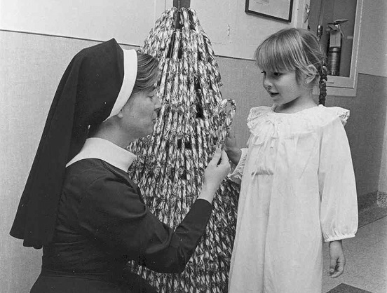 Sister giving girl a candy cane ca '60