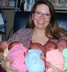 Mother cradling quintuplets in her arms
